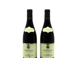 two bottles of wine sitting next to each other on a white surface