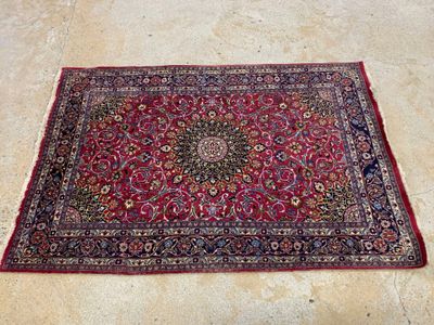 un tapis oriental posé au sol, sur fond rouge