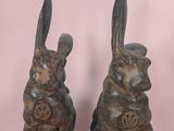 pair of antique bronze rabbit bookends on a pink background