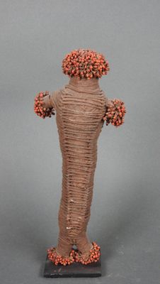 statue d'un homme portant un chapeau et dont les bras sont enroulés de fil