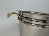 a silver pot with a handle on a table