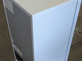 a white refrigerator sitting on the floor in a warehouse