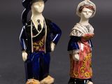 deux figurines d'un homme et d'une femme debout l'un à côté de l'autre