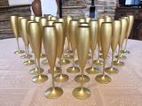 a lot of gold wine glasses sitting on a table