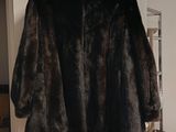 a fur coat hanging on a rack in a room