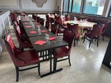 tables and chairs are set up in a restaurant with a bar in the background