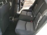 the back seats of a white car with a black seat belt