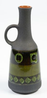 un vase vert et noir orné d'un visage
