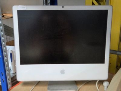 un écran d'ordinateur Apple posé sur un bureau en bois
