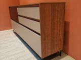 an image of a dresser in a room with orange walls