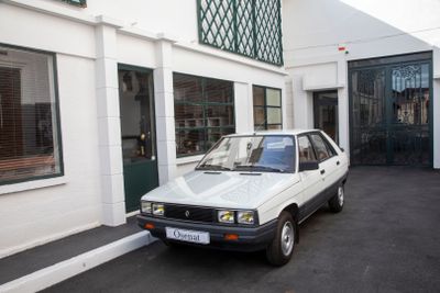 a small white car parked in front of a building