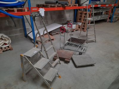 une échelle posée dans une pièce, à côté d'un tas de bois