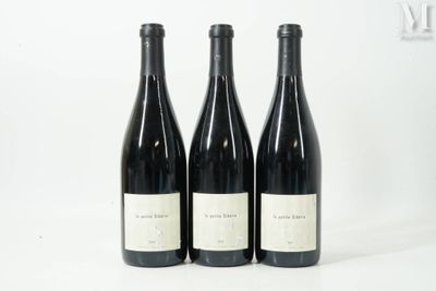 trois bouteilles de vin sont alignées sur une surface blanche