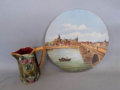 a picture of a painting on a plate next to a vase