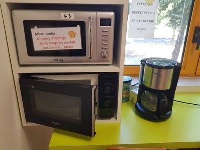 two microwaves and a coffee maker on a green table