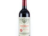 une bouteille de vin rouge posée sur une table blanche