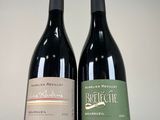 two bottles of red wine sitting next to each other on a table