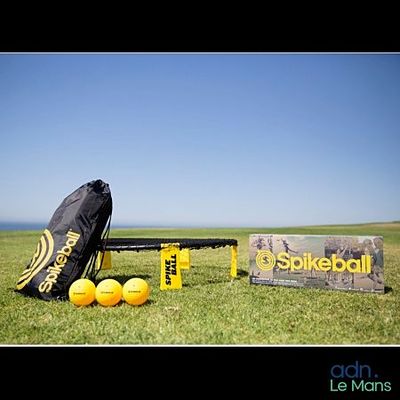 un sac de balles posé sur l'herbe à côté d'un panneau
