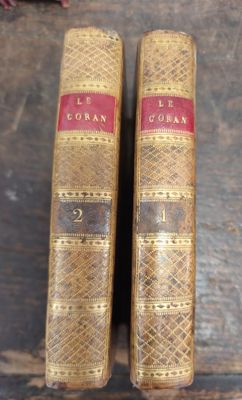 deux vieux livres posés l'un à côté de l'autre sur une table en bois