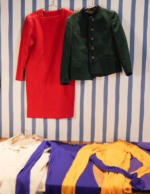 un lit avec des vêtements accrochés au mur à côté