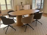 une table et des chaises dans une pièce avec une grande fenêtre