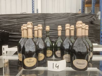 plusieurs bouteilles de champagne posées sur une étagère dans un magasin