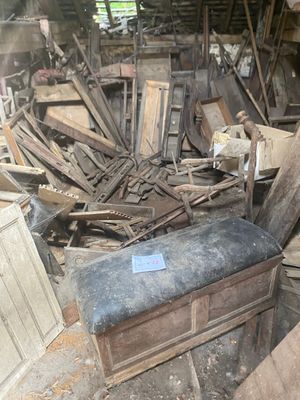 a pile of old furniture in a room with a lot of wood