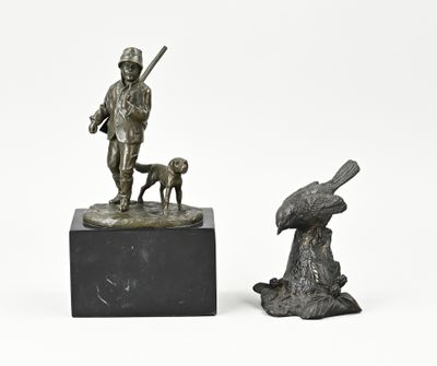 deux sculptures en bronze représentant un homme avec un chien et un oiseau