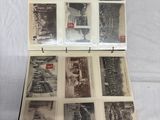 a lot of old photos in a box on a bed