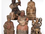 plusieurs figurines sculptées représentant des personnes d'origine asiatique assises sur un banc