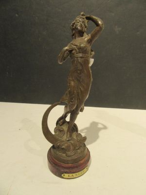 statue en bronze représentant une femme avec un serpent, posée sur un socle