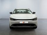 the front of a white car in a room with a black floor