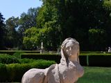 a statue of a dog sitting on a stone wall