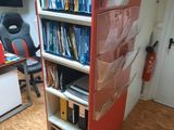 a book shelf with many books on it in a room