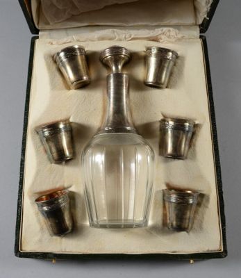 une bouteille en verre et six tasses dans une boîte