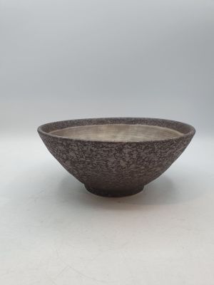 un bol noir et blanc posé sur une table blanche