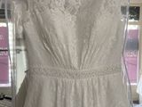 wedding dress hanging on a hanger in a bridal shop
