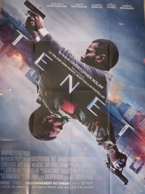 affiche de cinéma représentant un homme tenant une arme à feu devant une ville