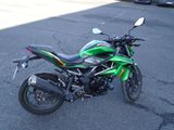 une moto verte et noire garée sur un parking