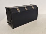 une vieille valise noire posée sur une table blanche