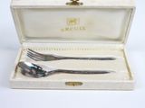 deux fourchettes et deux cuillères dans une boîte posée sur une table