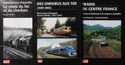 trois livres posés sur une table, avec des images de trains sur la couverture
