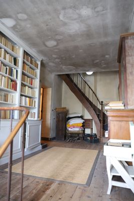 une pièce avec un escalier et des bibliothèques