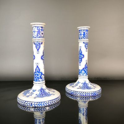 two blue and white vases sitting on a black table