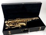 a gold saxophone in a black case on a white background