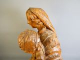une statue en bois représentant une femme tenant un enfant