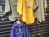 de nombreuses vestes accrochées à un mur dans un magasin