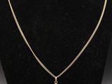 un collier avec une croix en or sur un mannequin, un mannequin, un mannequin, un mannequin, un mannequin, un mannequin, un mannequin, un mannequin, un manne