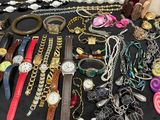 many different types of watches and bracelets laid out on a table