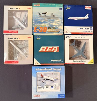 six boîtes contenant divers modèles réduits d'avions, posées sur une table